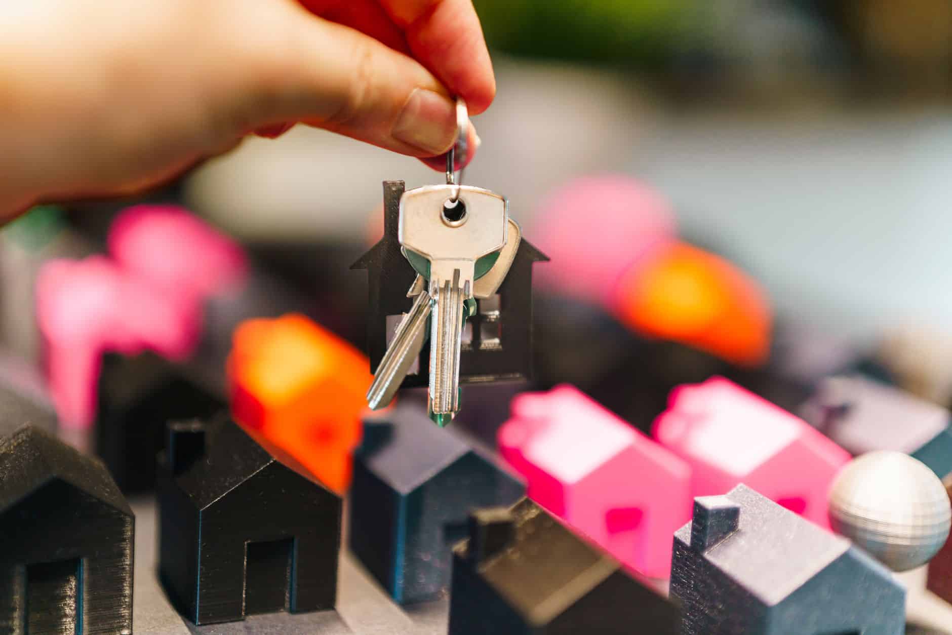 miniature houses and keys symbolize real estate choices